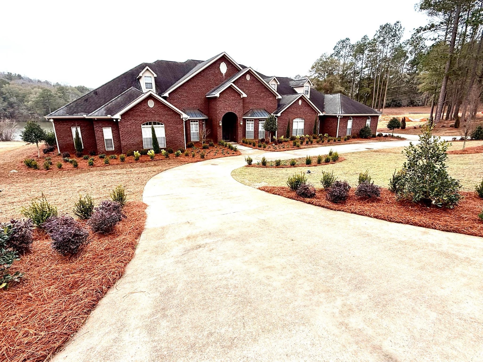 Original project photograph of a red brick home with newly installed landscape beds
