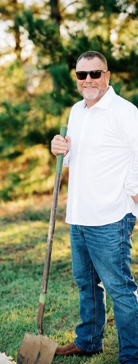 Matt Carden outdoors with a shovel